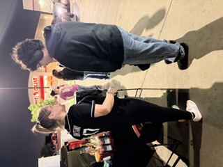 Guests chatting with the Aguas Güey team at the booth after dark