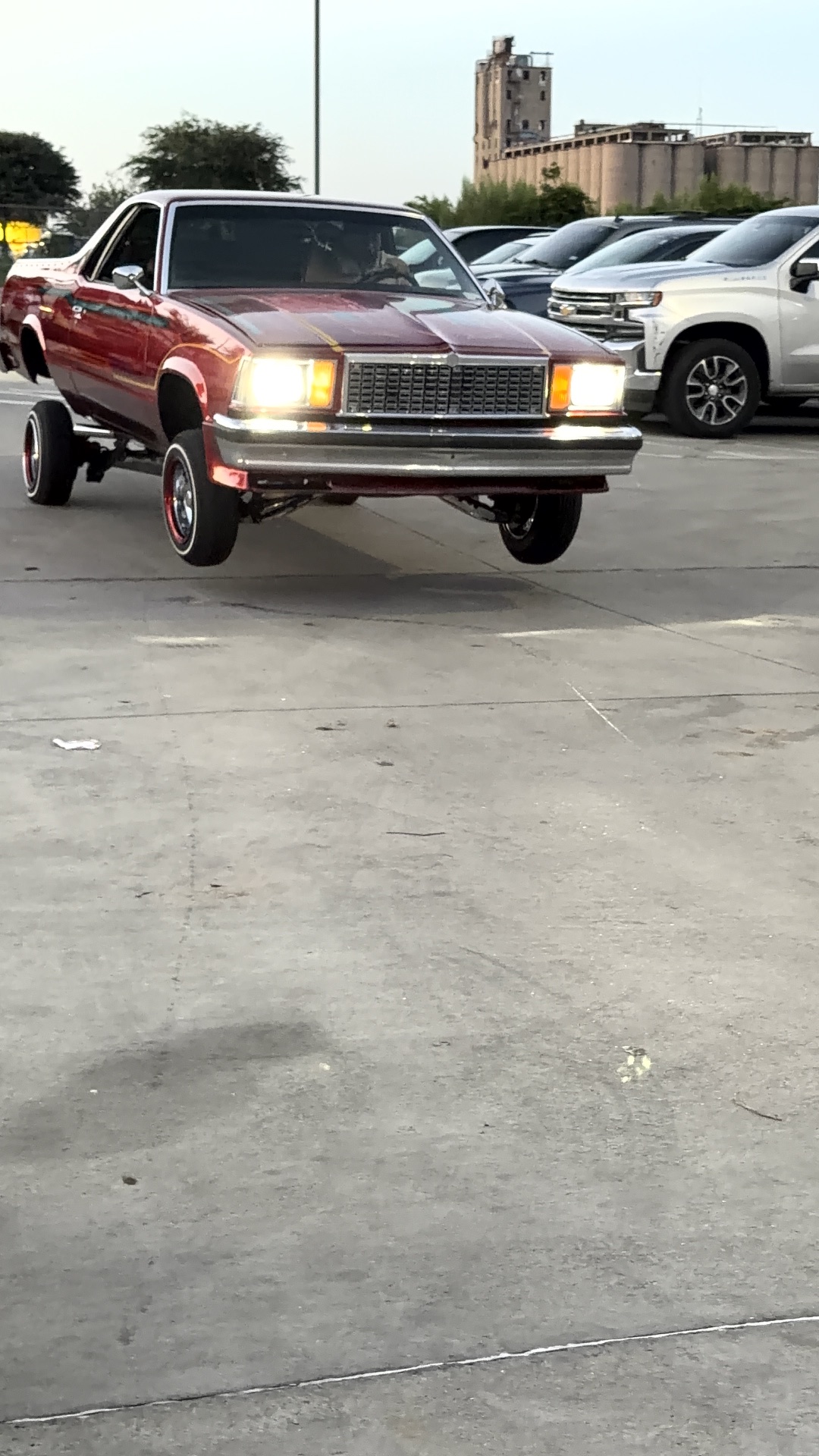 Candy red El Camino lowrider hopping on three wheels